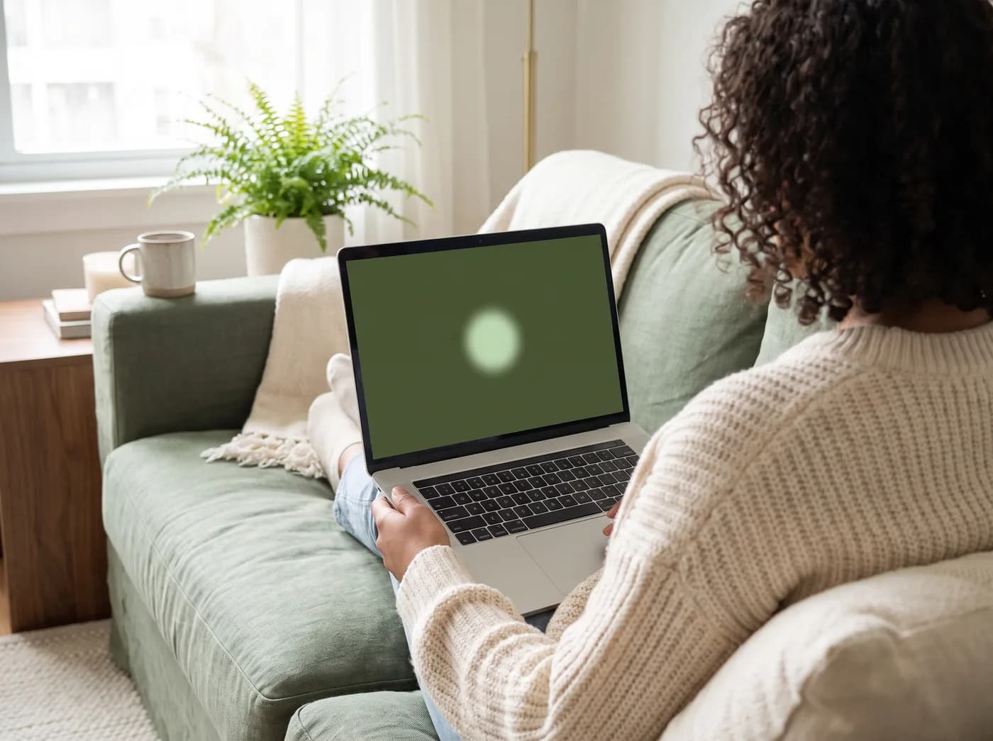 Person on a sofa following a single dot on a laptop screen